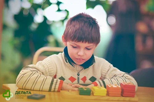 Ребёнок сидит перед головоломкой